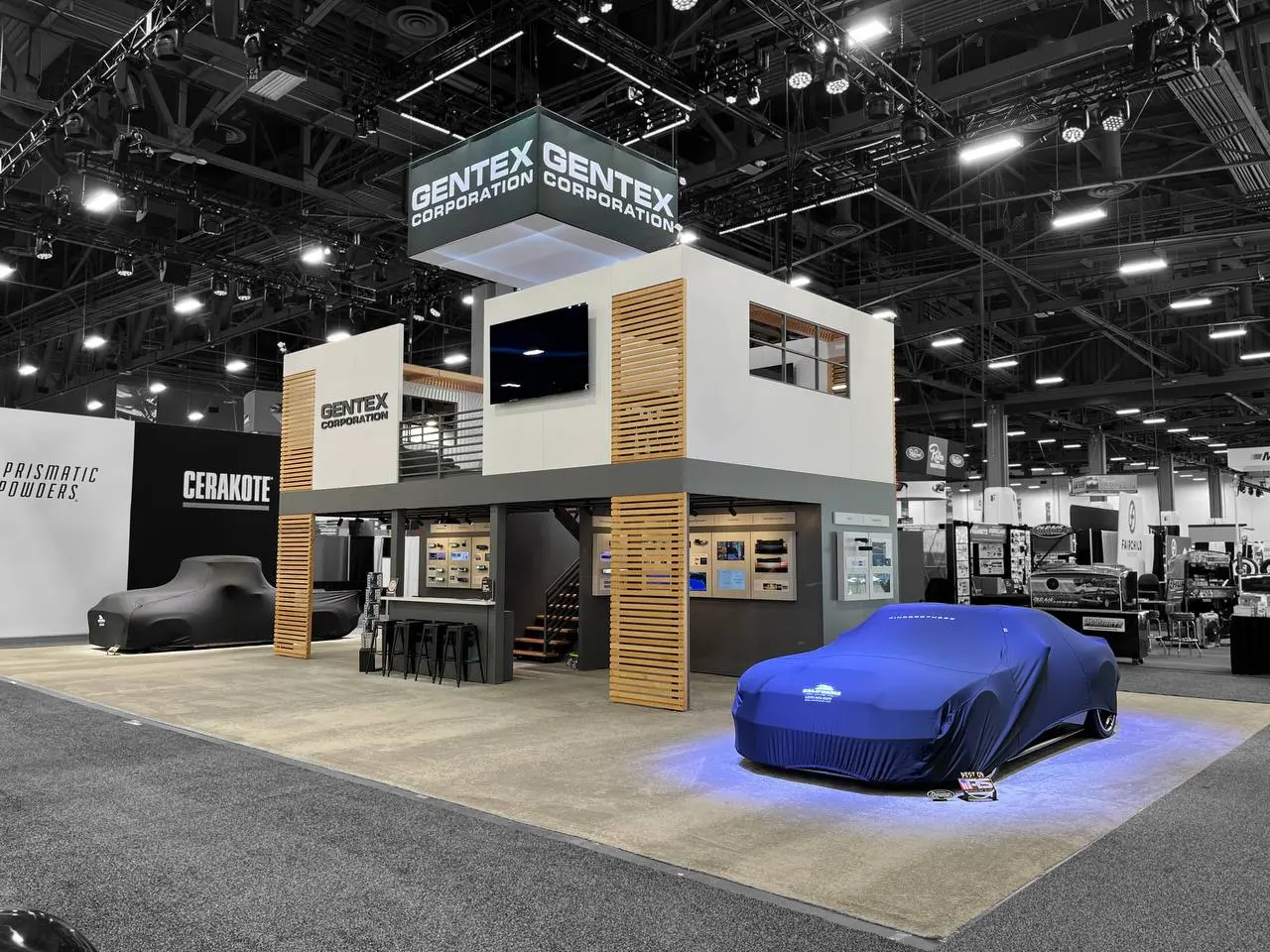 Gentex booth with blue-lit covered vehicle display